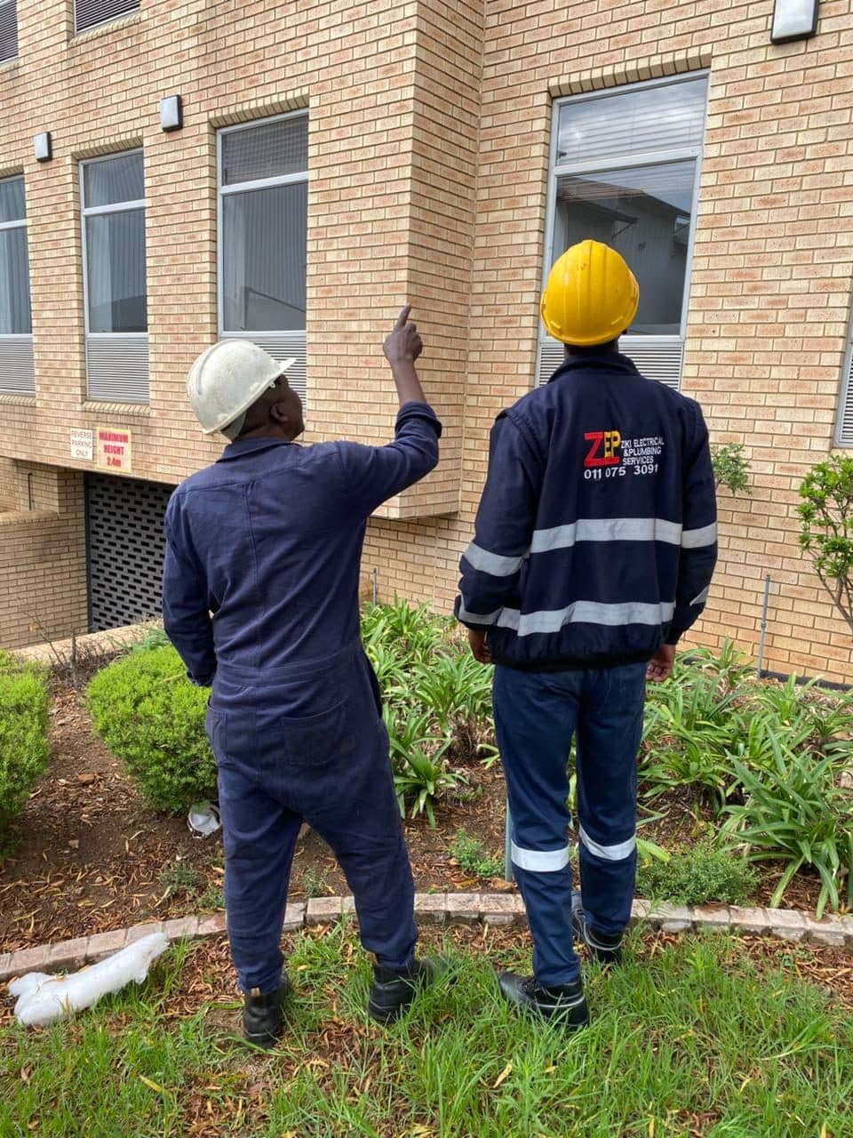 ZEPS technicians inspecting a brick building